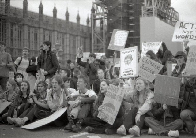 a croud of youngsters sitting in protest with banners